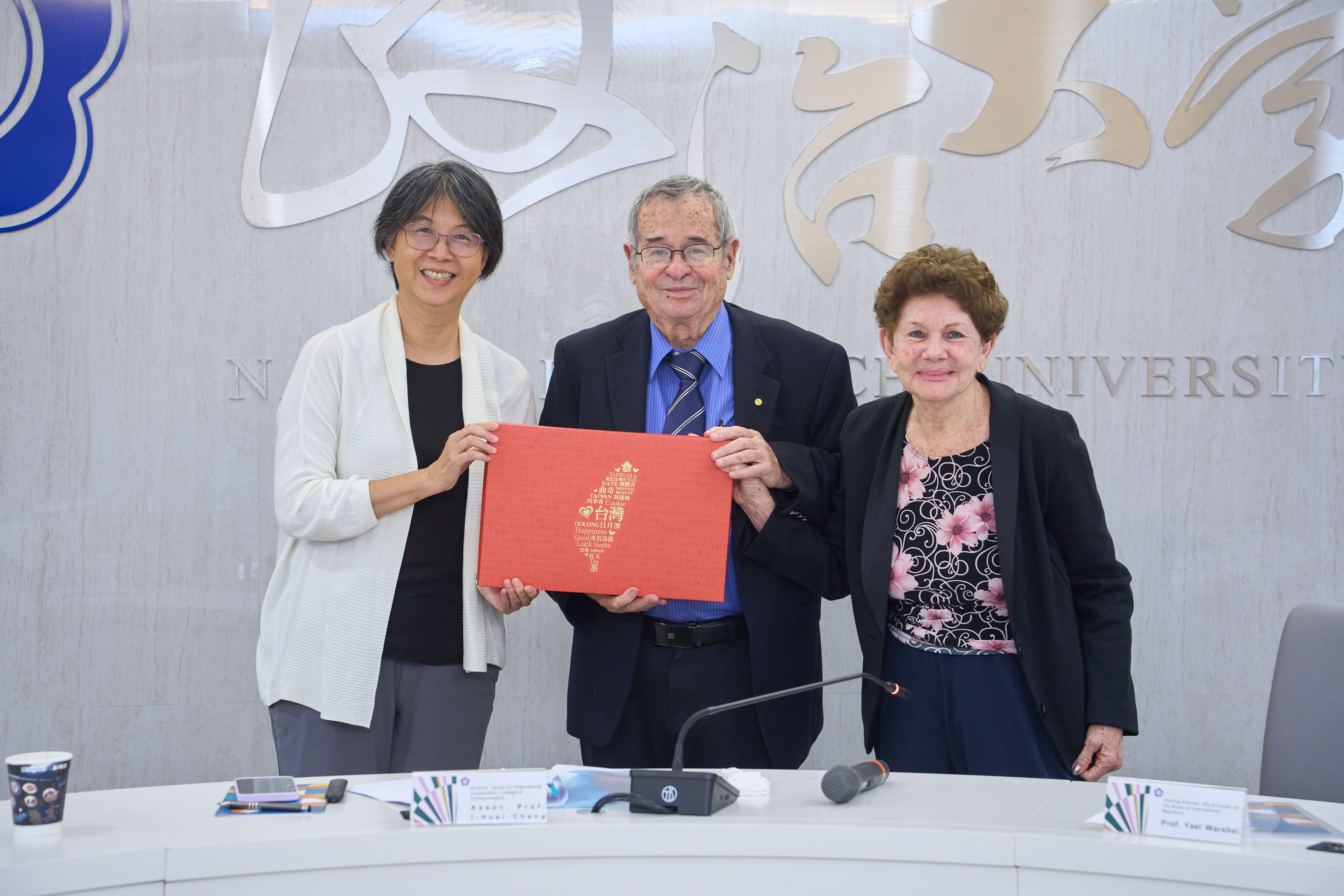Dean Hsiu-Hui Sun of the College of Communication presents Taiwanese souvenirs to the distinguished guests.(From left: Dean Hsiu-Hui Sun, Dr. Arieh Warshel, and Mrs. Warshel.)